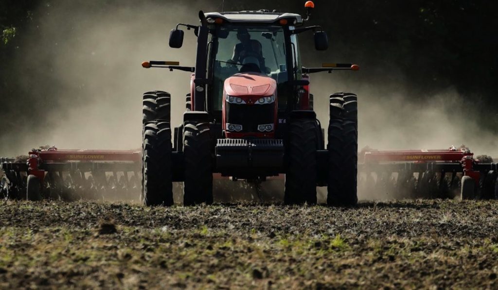 A Massey Ferguson Tractor pulls a vertical tillage machine over farmland in Missouri.